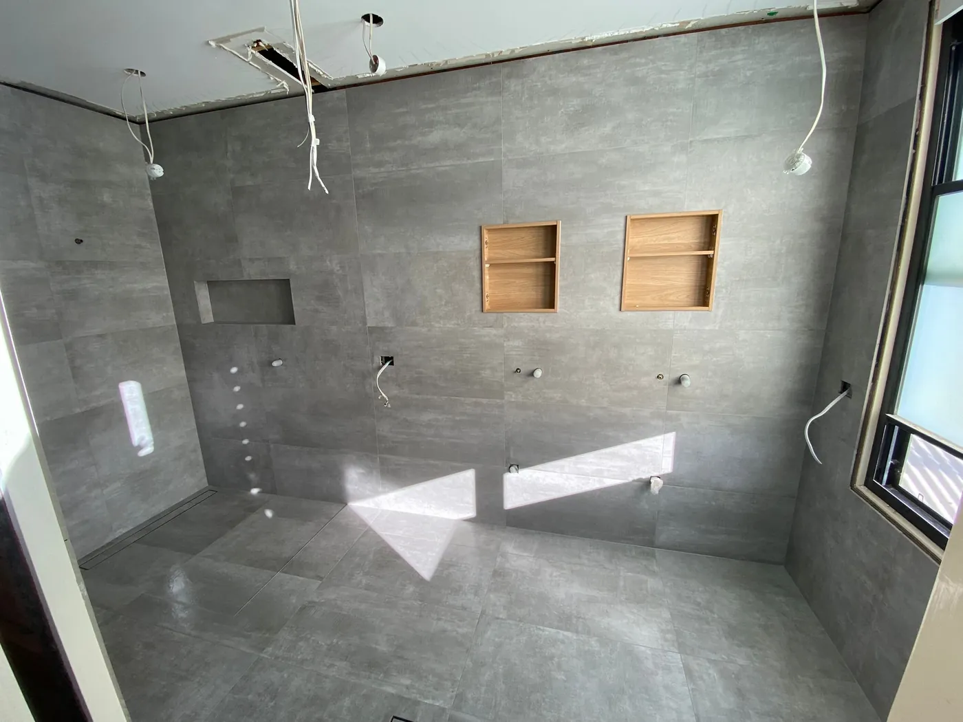Bathroom mid-build with timber-lined niches, set out and sealed before tiling